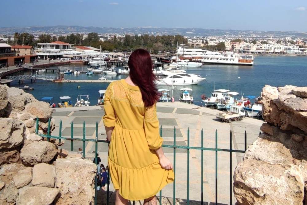 Kleidis naine seisab mere ääres